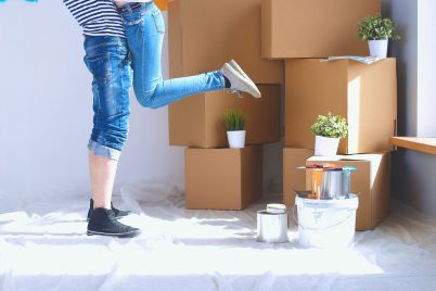 a woman standing in front of a pile of boxes.