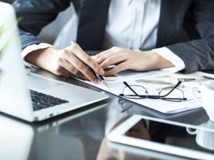 a person sitting at a desk working on a laptop.